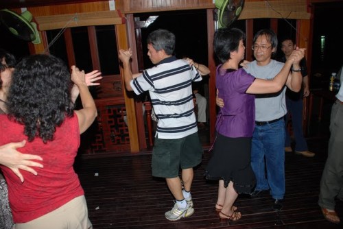 Few couples dancing on the deck of Halong boat